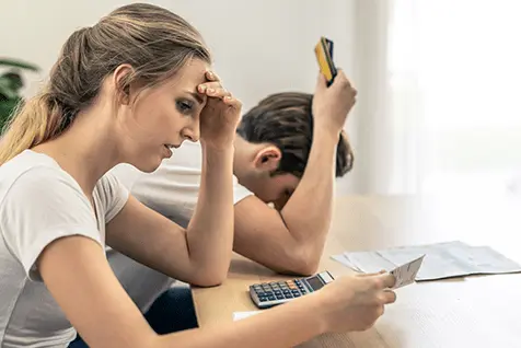 Pareja joven en casa evaluando diferentes opciones de tratamiento para el atraso menstrual.